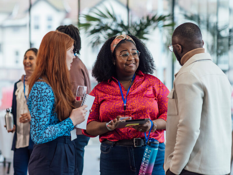 Three people talking to each other at a conference