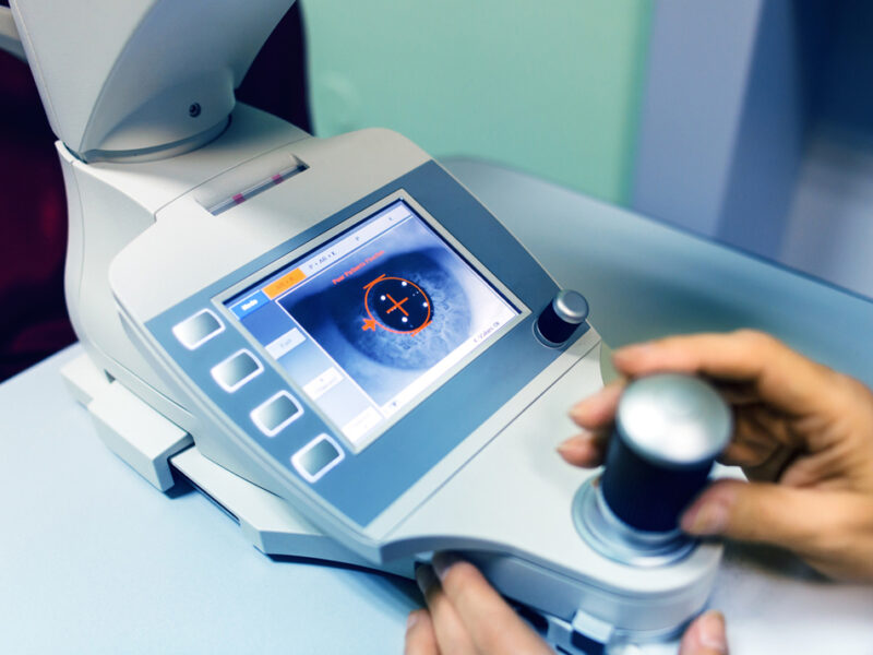 a doctor looking at someones eyes through a machine